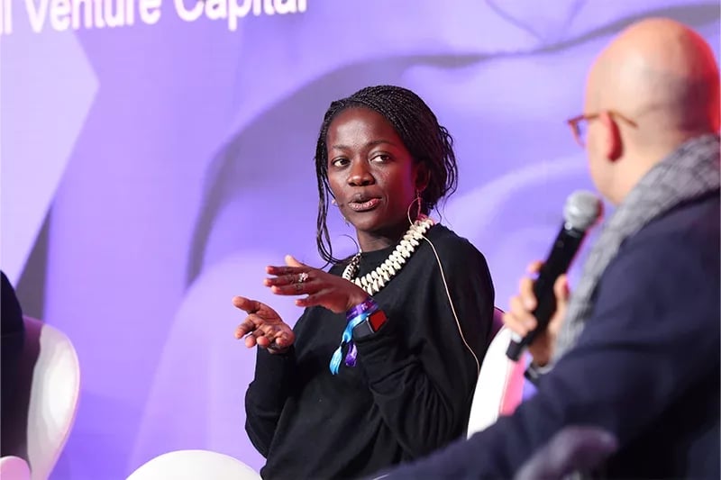 Two panelists engaged in a discussion at a 4YFN event, with one speaker using expressive hand gestures while emphasizing a point, set against a vibrant purple backdrop featuring the event's branding.