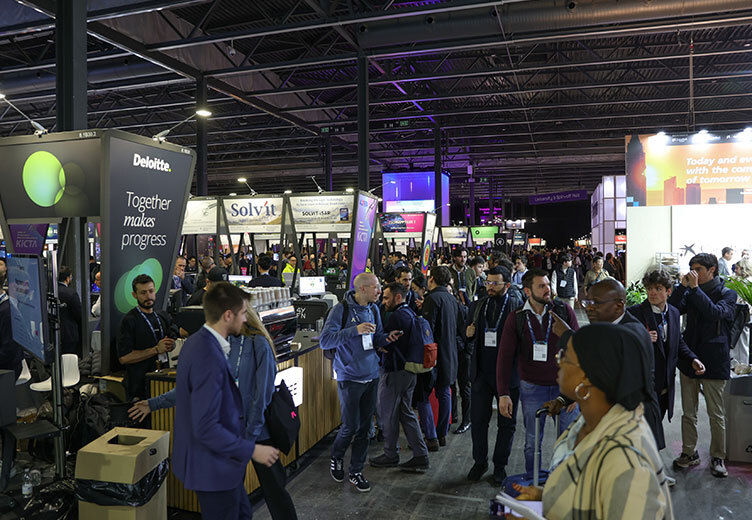 Crowds of attendees explore startup booths at the 4YFN 2026 exhibition hall, engaging with exhibitors like Deloitte and other tech companies in a bustling, modern event space filled with signage, lighting, and networking activity.